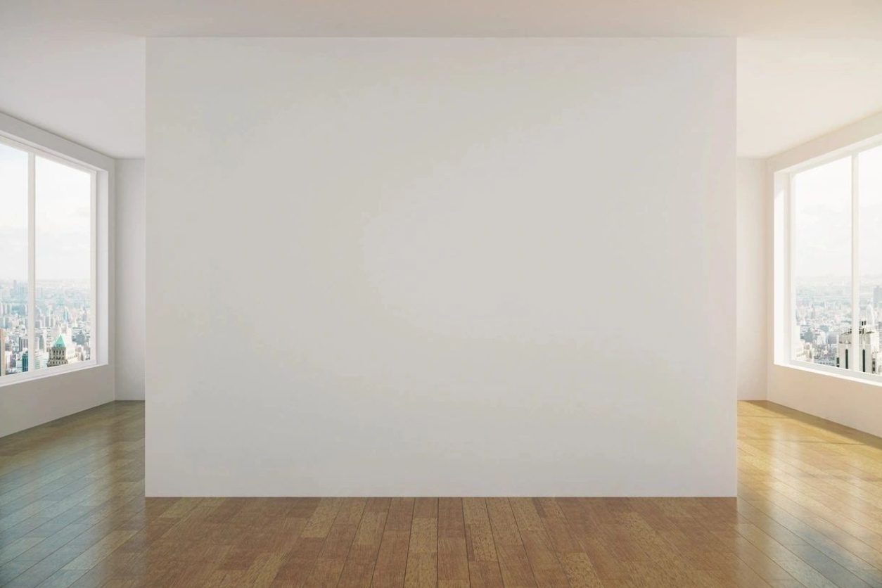 A white wall with wood floors in front of it
