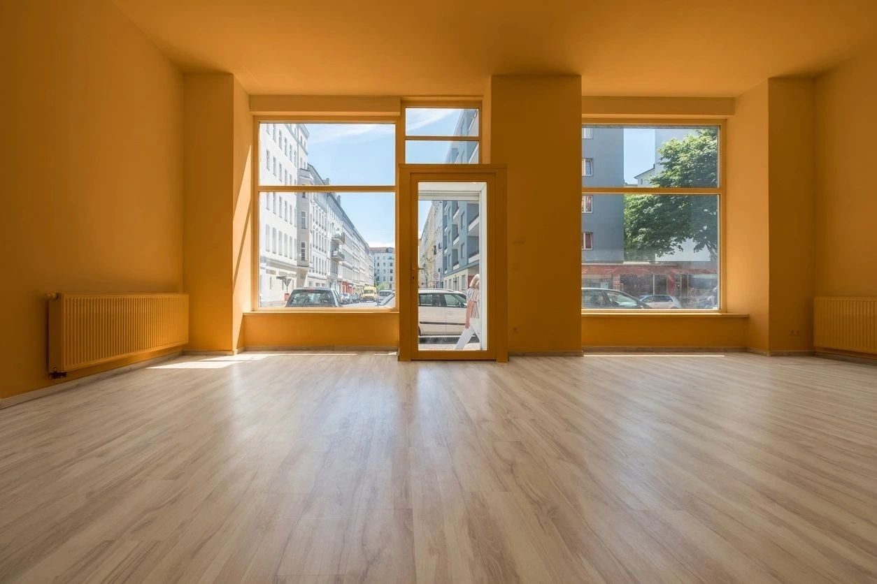 A room with a large window and wooden floors